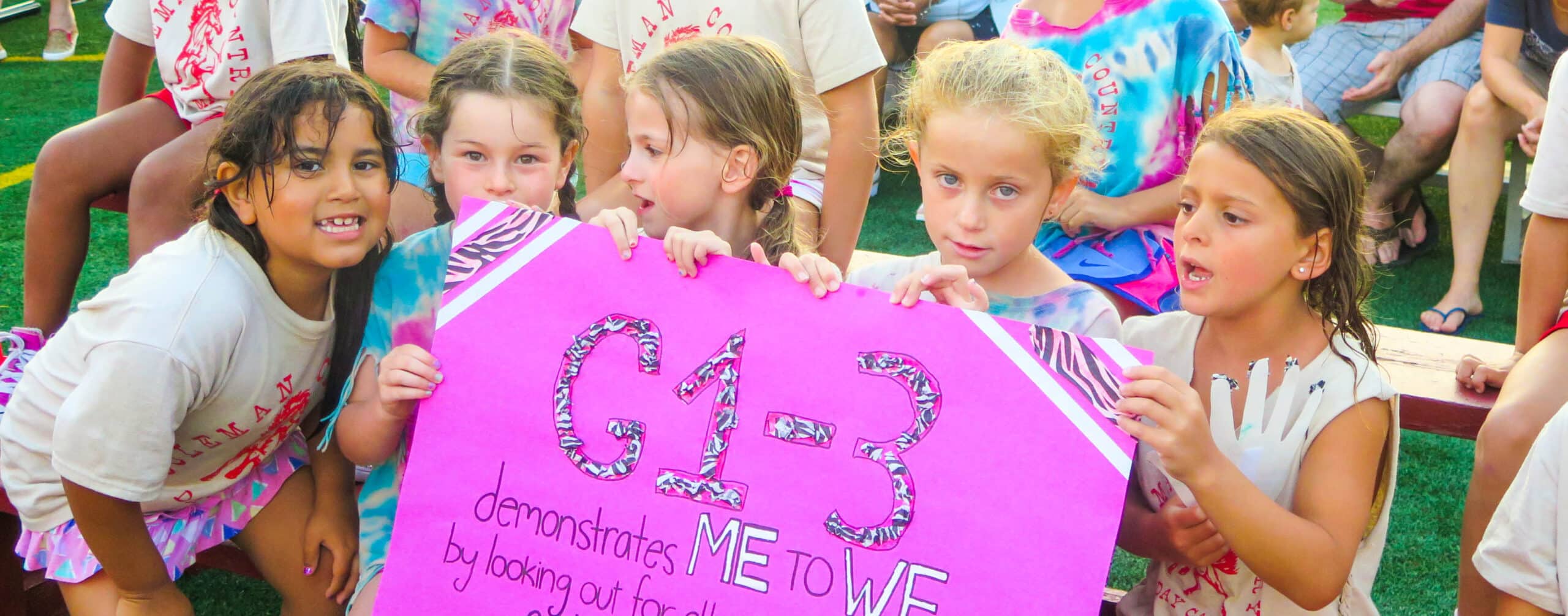 Campers holding up a sign.