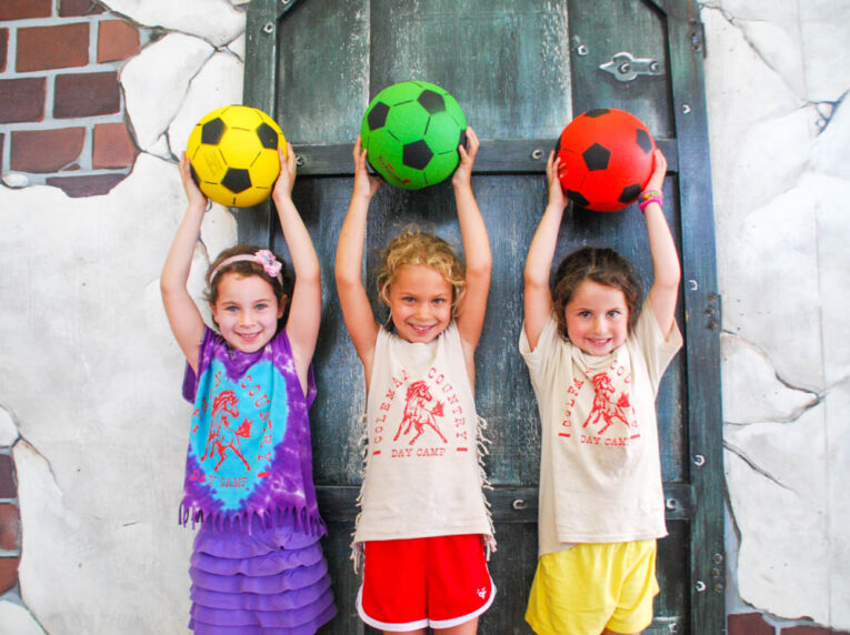 Three Scout campers holding soccer balls.