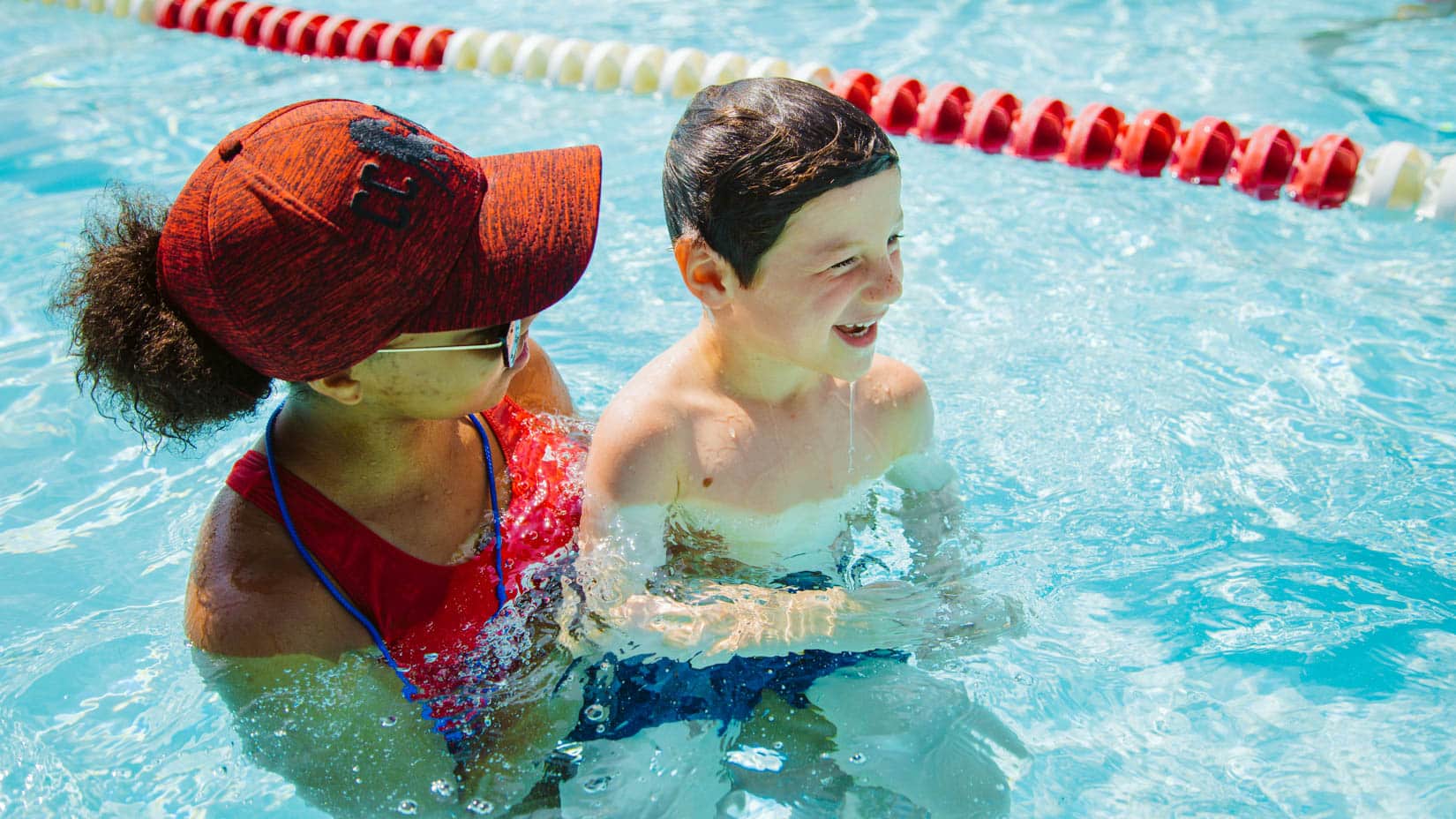 Lifeguard with a camper in the pool.