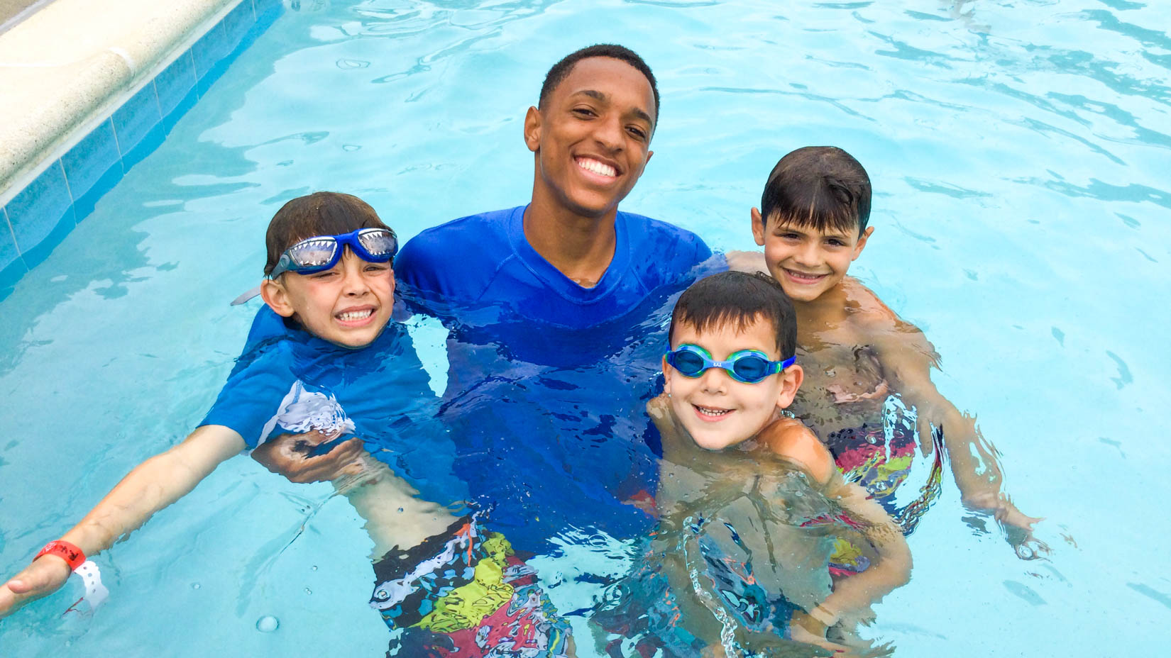 Counselor in the pool with campers.