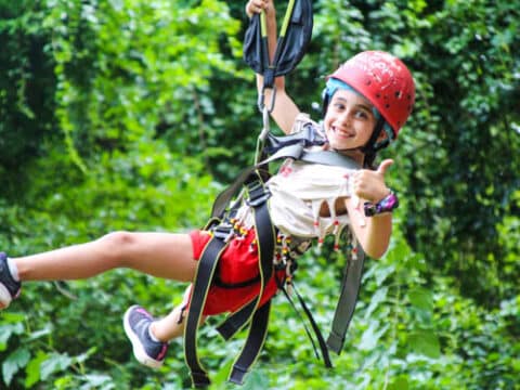 Camper giving a thumbs up on the zipline.
