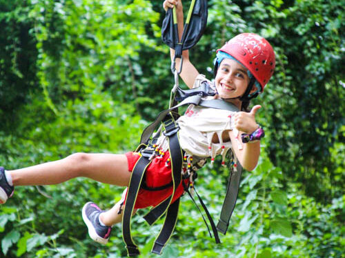 Camper giving a thumbs up on the zipline.